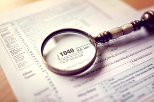 Magnifying glass over a Form 1040 tax form